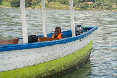 Boy sitting on boat in lake