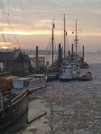 Boats in harbor at sunset