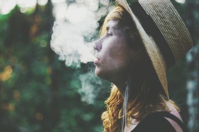 Close-up of woman exhaling smoke outdoors