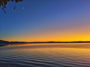 Scenic view of lake against clear sky during sunset