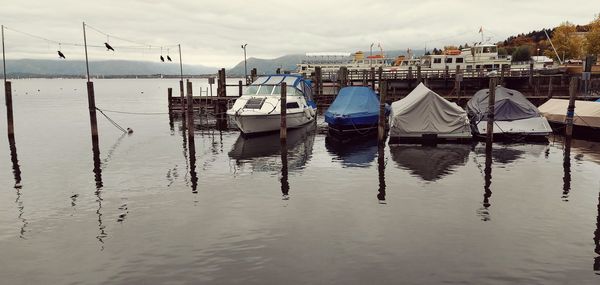 Boats moored in sea against sky