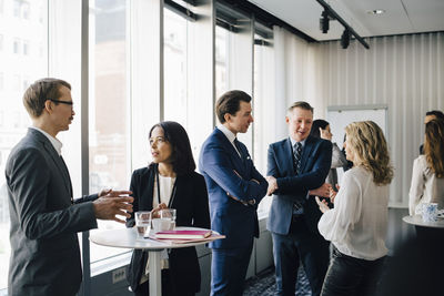 Male and female colleagues discussing in office seminar