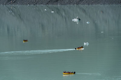 High angle view of people sailing boat in lake at tasman glacier