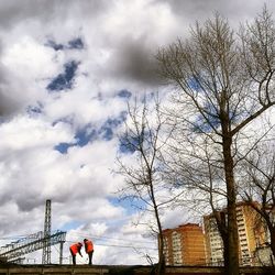 Low angle view of bare tree against cloudy sky