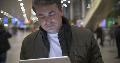 Portrait of man using mobile phone at night