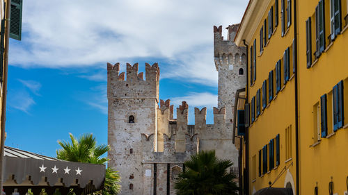 Low angle view of buildings against cloudy sky