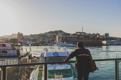 Boat in river with city in background