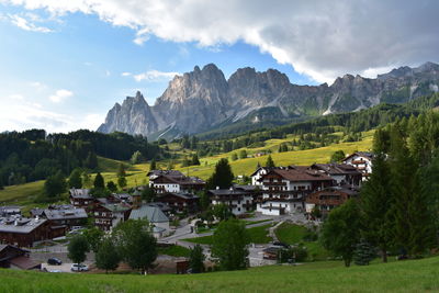 Houses by trees and mountains against sky