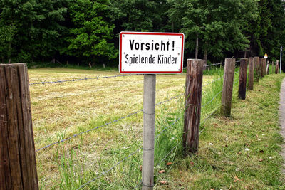 Information sign on wooden post in field