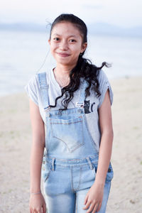 Portrait of smiling young woman standing on beach