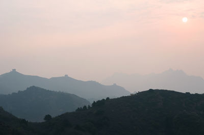 Scenic view of silhouette mountains against sky at sunset