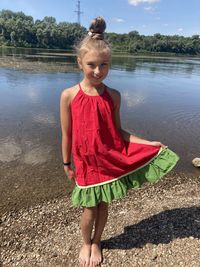 Portrait of woman smiling while standing by lake