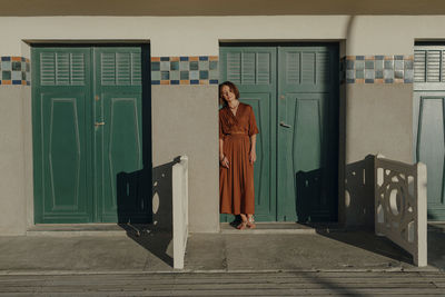 Woman leaning on door in resort at deauville, france