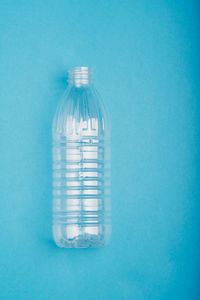 Empty plastic bottle over blue background. collecting plastic waste to recycling