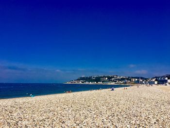 Scenic view of beach against blue sky