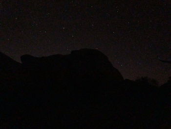 Low angle view of silhouette moon against sky at night