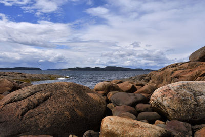 Rocks by sea against sky