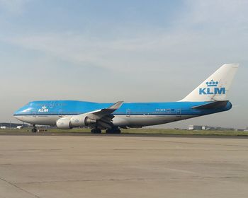 Airplane on runway against sky