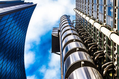 Low angle view of modern building against cloudy sky