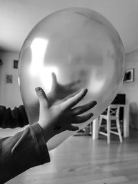 Close-up of hand holding ball at home