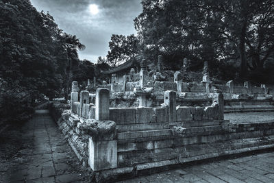 Cemetery by trees against sky