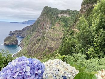 Scenic view of sea and mountains against sky