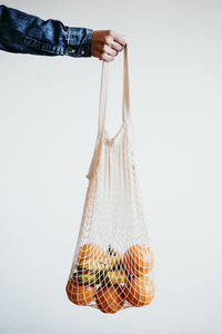 Woman han holding modern shopping white textile bag with oranges. zero waste