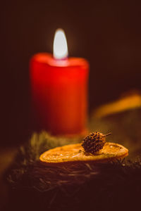 Close-up of candle on table against black background