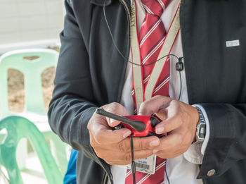 Midsection of security officer with walkie-talkie