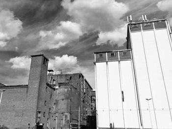 Low angle view of buildings against cloudy sky