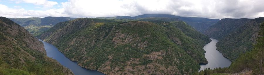 Panoramic view of river amidst mountains against sky