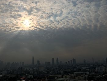 Aerial view of buildings in city against sky during sunset