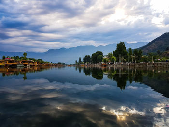 Scenic view of lake by buildings against sky