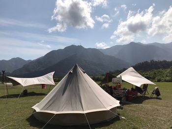 Tent on field by mountains against sky