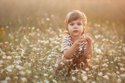Portrait of cute boy amidst flowers