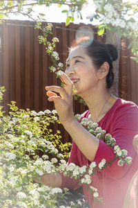 Woman holding red flowering plants