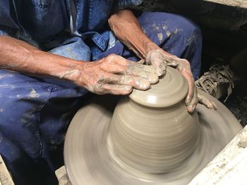 Midsection of craftsperson doing pottery