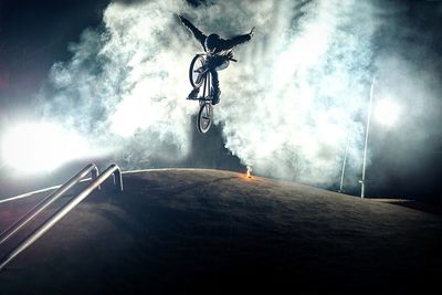 Low angle view of young man in mid-air with bicycle