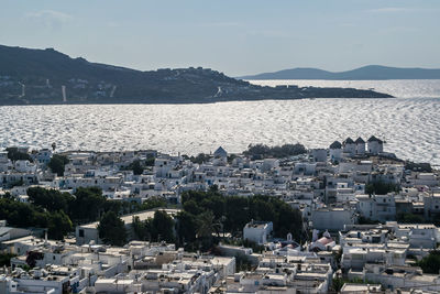 High angle view of townscape by sea against sky