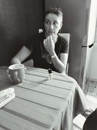 Portrait of young woman sitting on wall