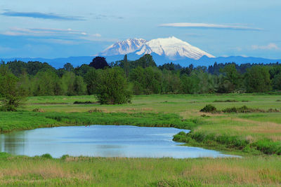 Scenic view of lake by mountain against sky