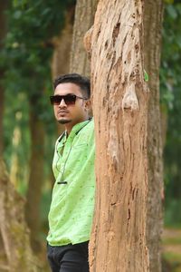 Portrait of young man standing in forest