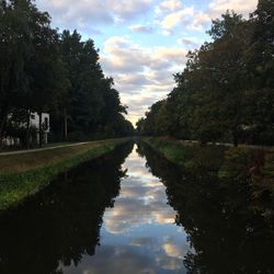 View of canal against cloudy sky