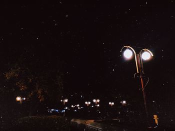 Low angle view of illuminated street light against sky