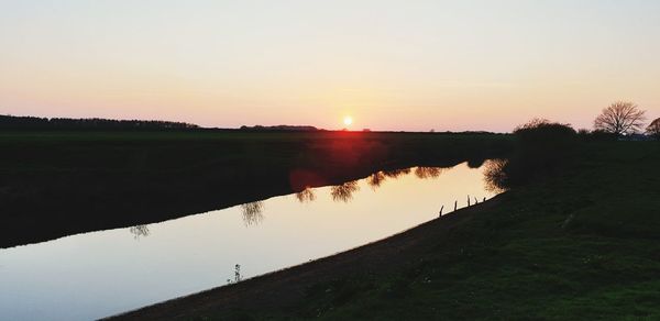 Scenic view of lake against sky during sunset