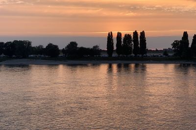 Scenic view of lake against orange sky