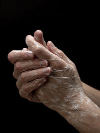 Close-up of hand over black background