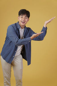 Portrait of smiling man standing against wall