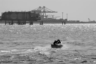 People swimming in sea against sky