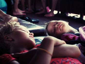 Siblings lying on bed